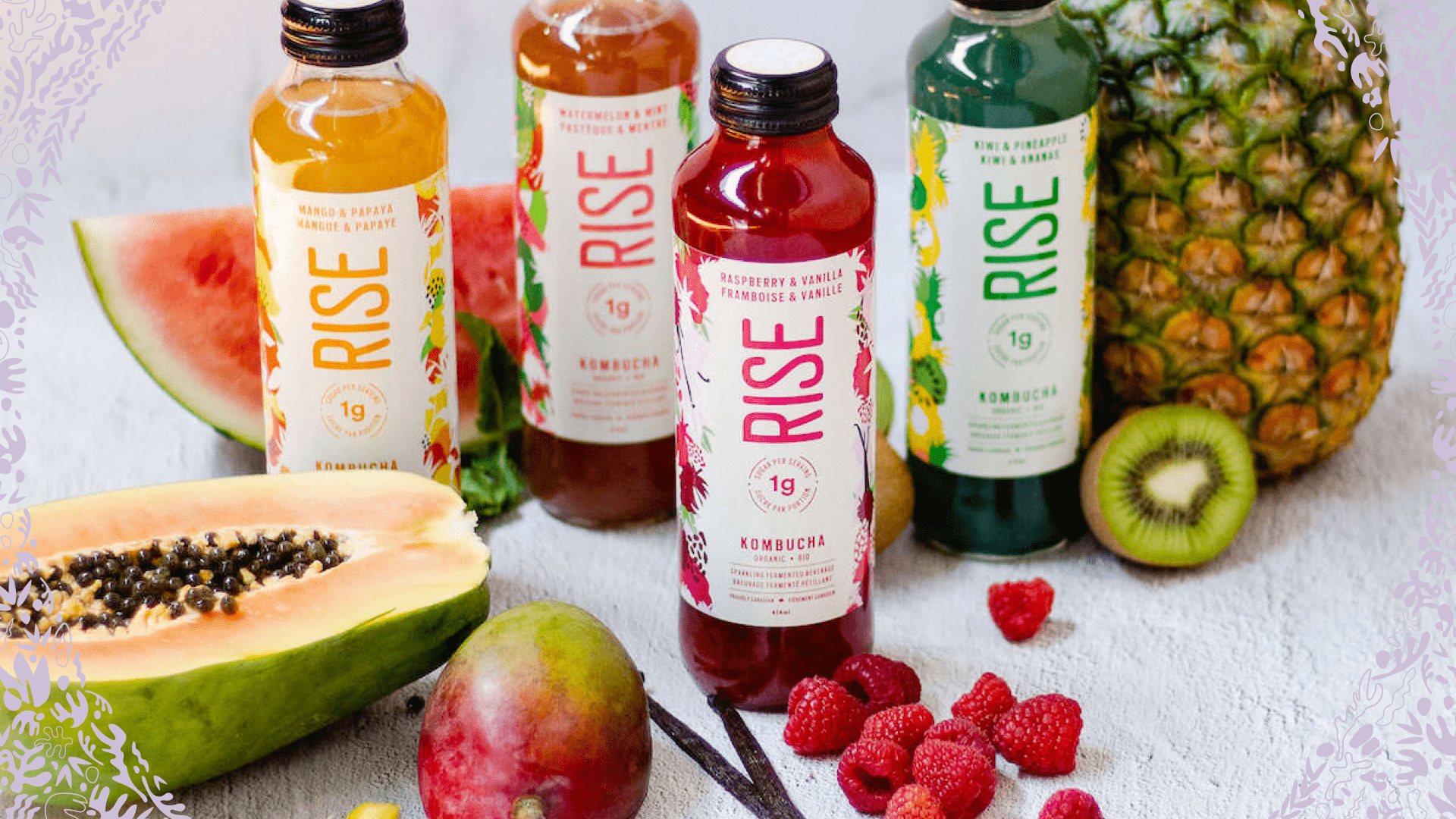 RISE kombucha bottles surrounded by various fruits