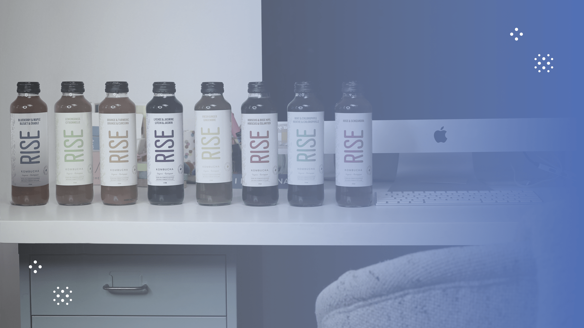 RISE kombucha bottles lined up on desk